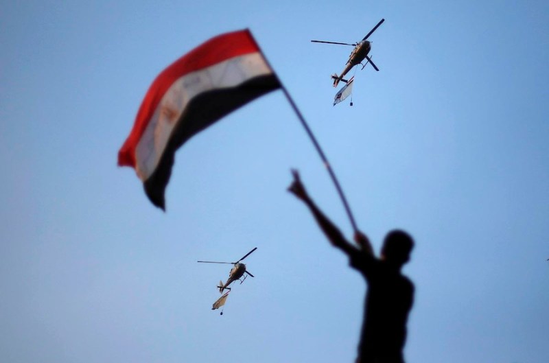 Egyptian military helicopters trailing national flags circled over Tahrir Square during a protest demanding that Egyptian President Mohamed Mursi resign in Cairo