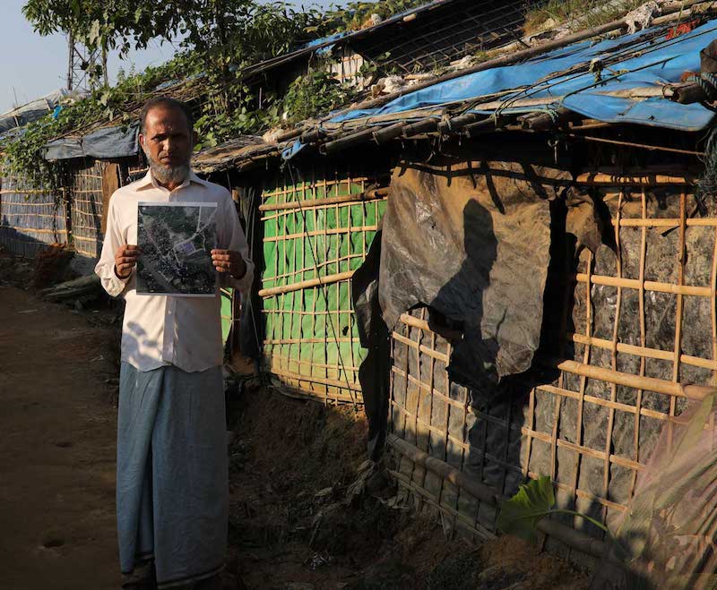 refugee in kutupalong camp with satellite picture of his old e village